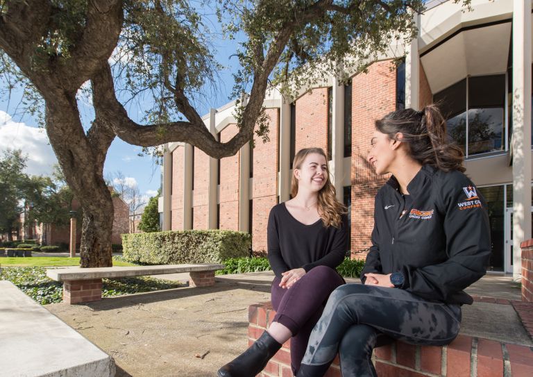 two students sitting on campus